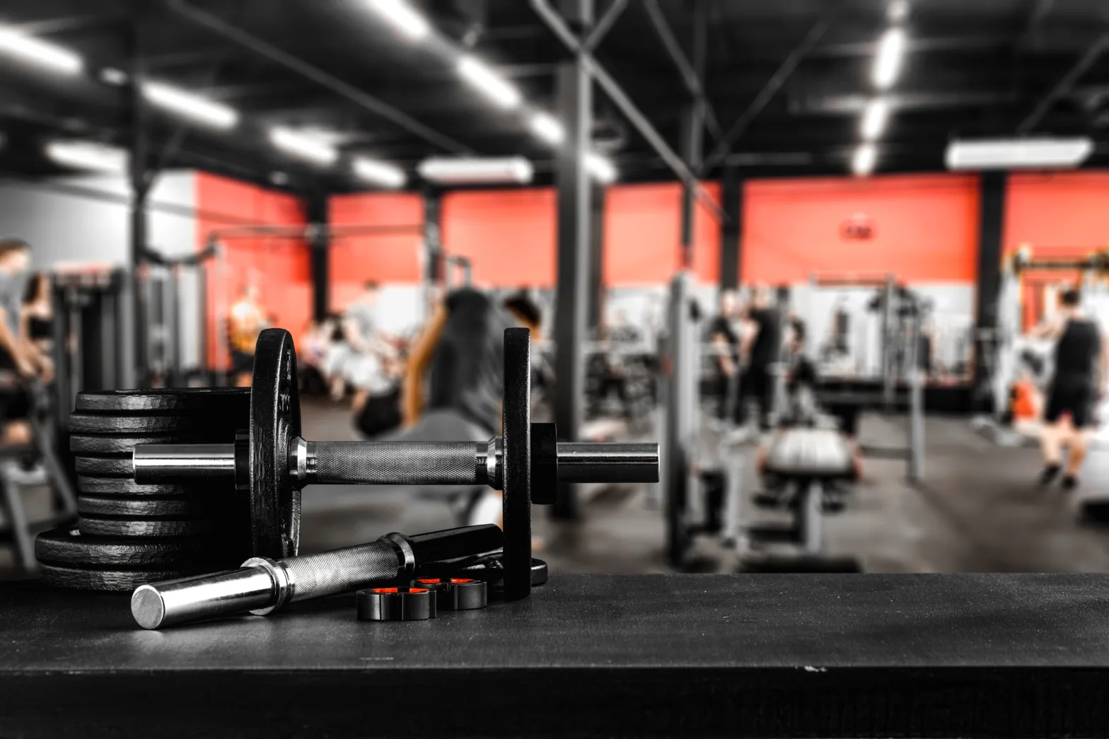 A stack of weights with a gym facility in the background.